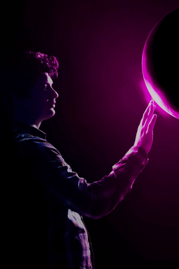 A man reaches his hand out to an unknown pinkish purple orb- perhaps a planet or perhaps a black whole depending on your perspective.